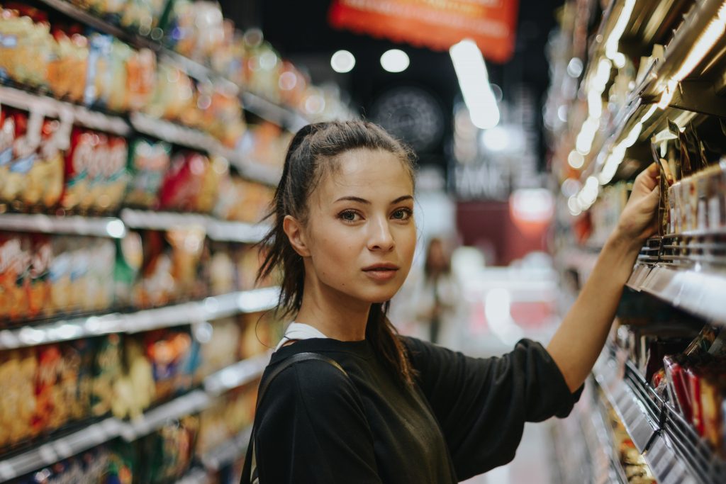 Une jeune femme qui fait ses courses dans un supermarché