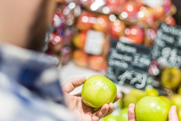 Un homme choisit des pommes dans un supermarché